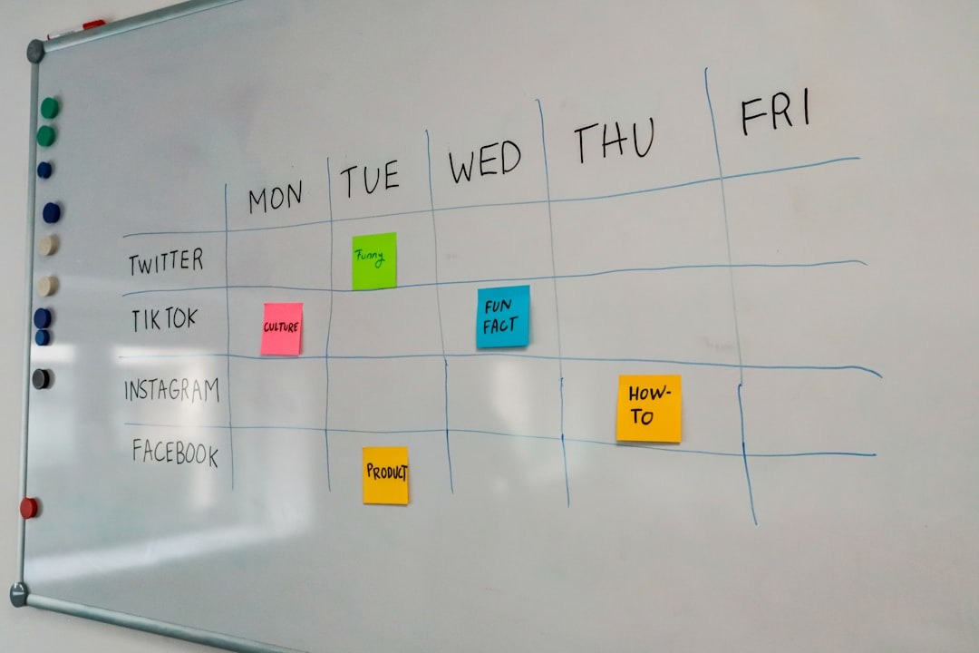 White magnetic whiteboard used as a social media content calendar with sticky notes.